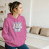 Woman wearing pink Washington University hoodie with blue-and-white logo.