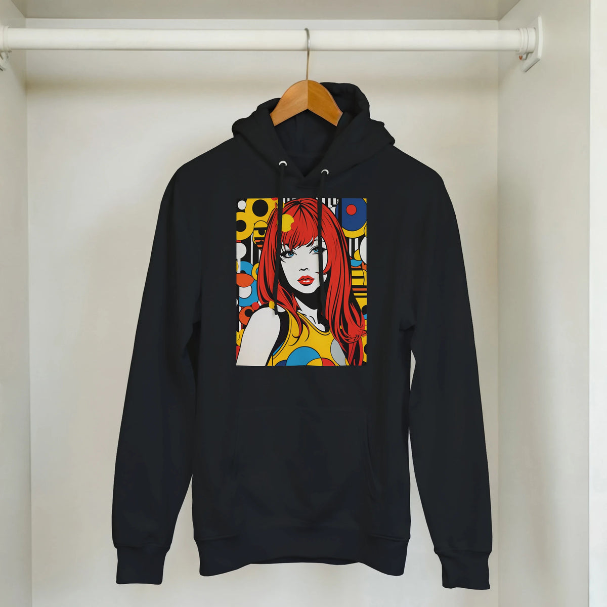 Black pullover hoodie featuring bold retro pop art graphic of a red-haired woman surrounded by colorful geometric shapes.
