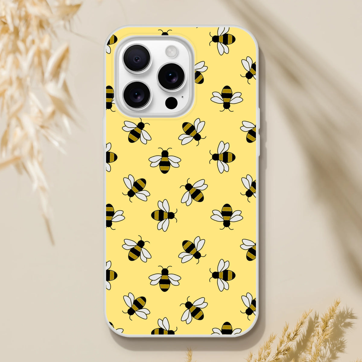 Yellow iPhone case featuring a playful honey bee pattern for iPhone 13–16.