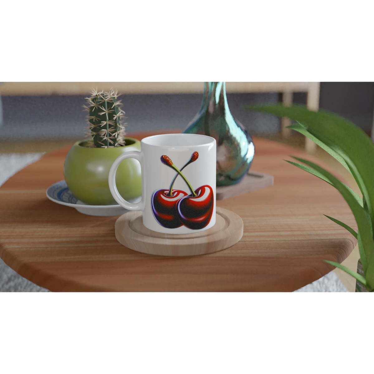 White mug with retro cherry design on a wooden table beside a small cactus and green vase.
