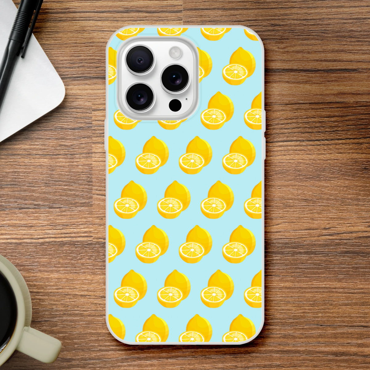 Pastel blue iPhone case featuring a yellow lemon pattern. Cute summer fruit TPU phone cover for iPhone 13-16, offering shock-absorbing protection on a wooden surface.