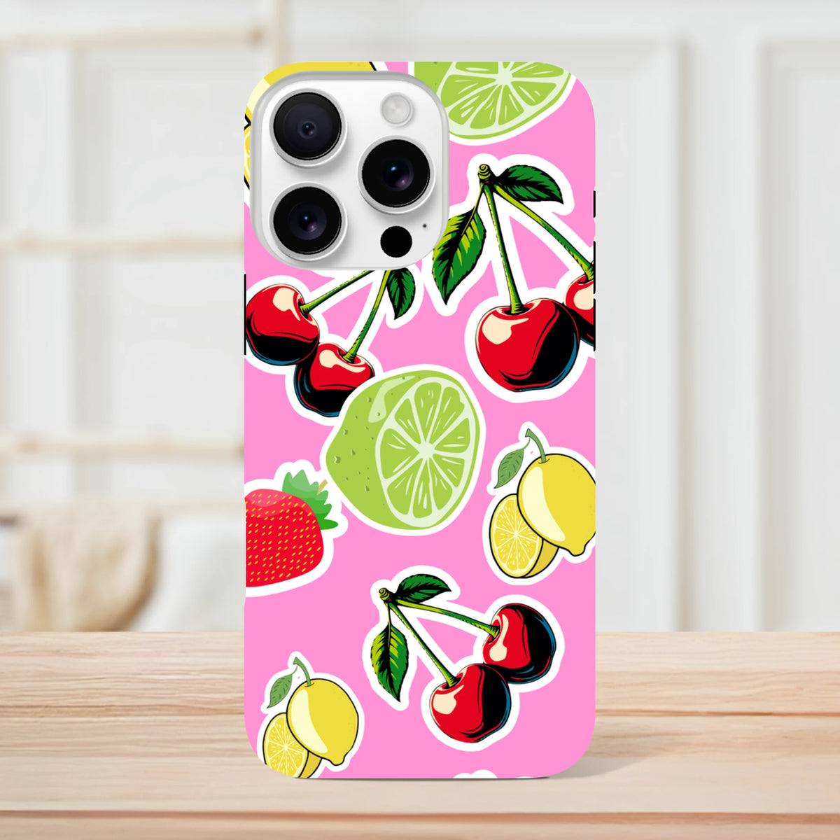 Pink iPhone case featuring a sticker-style pattern of cherries, limes, and lemons on a bright pink background.