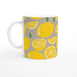 Lemon-pattern mug with yellow slices and green leaves on gray background, white handle.