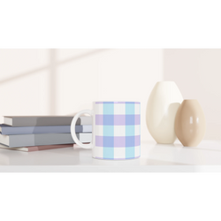 Pastel Blue Gingham Ceramic Mug with a checkered pattern on a white desk among other mugs.