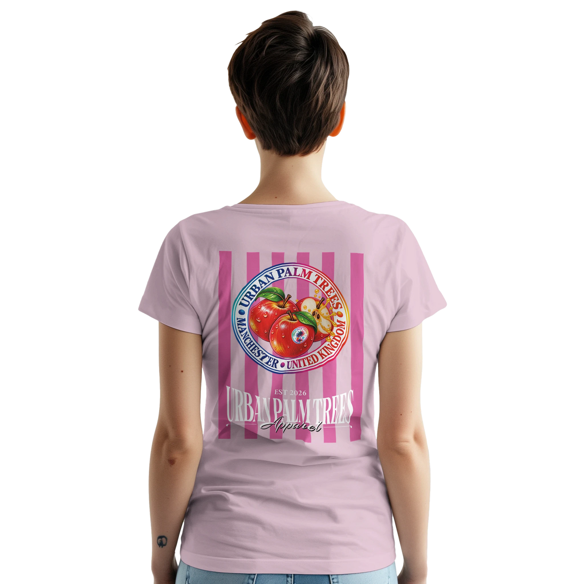 Back view of woman wearing pink graphic tee featuring retro striped red apple fruit print and Urban Palm Trees logo.