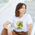 Woman wearing white Lemons graphic T-shirt with a yellow lemon illustration, casual outdoor look.