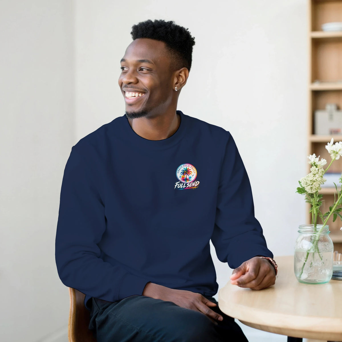 Man wearing navy Tucked Stance car sweatshirt with colorful urban palm trees and Full Send graphic on the chest.
