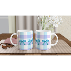 Blue Gingham Bow Mugs with pastel blue stripes and teal bows on a checkered table, bouquet in background.