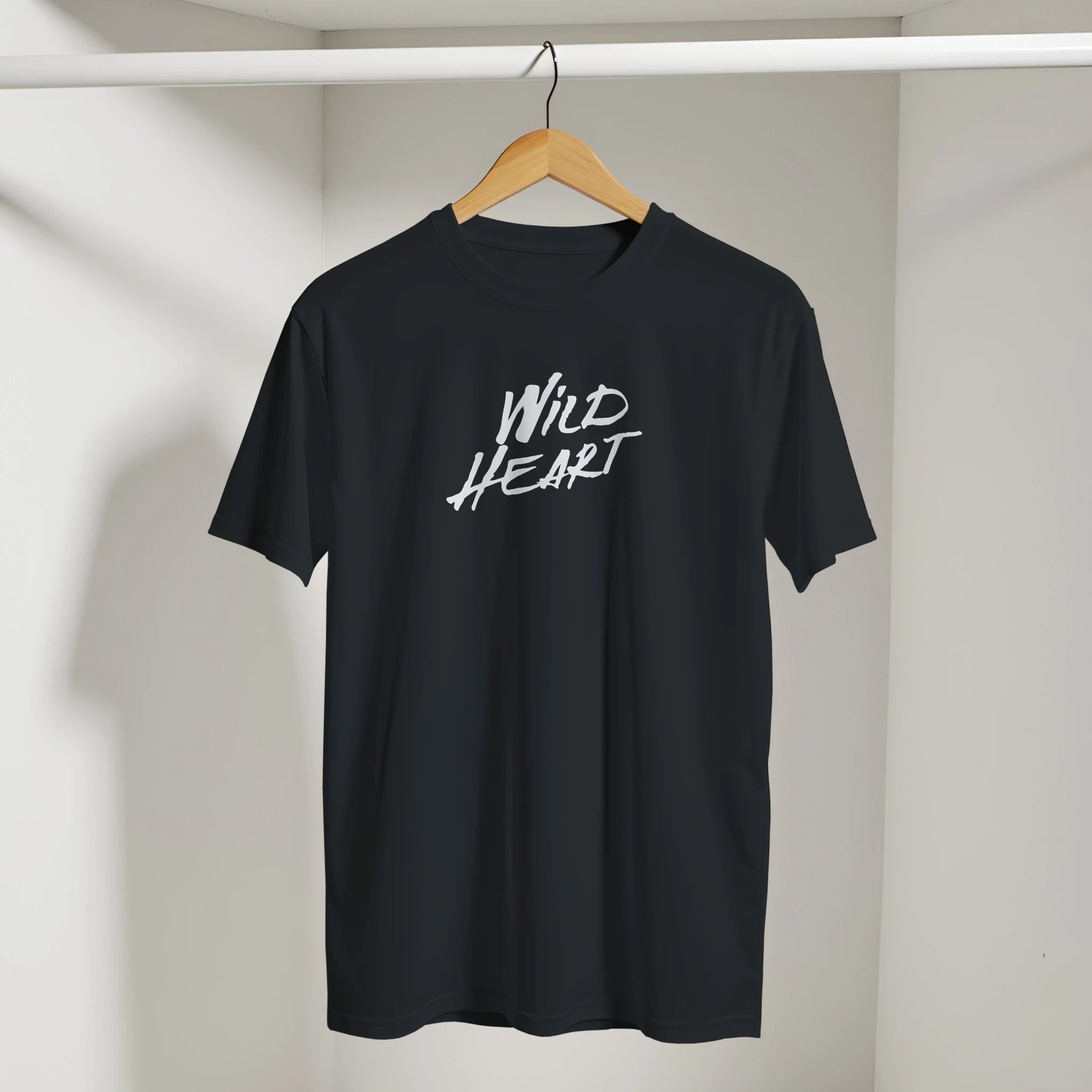 Black Wild Heart T-Shirt on a wooden hanger with white script text WILD HEART.