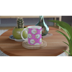 Pink aesthetic sheep ceramic mug with lamb illustrations on a wooden table beside a cactus.