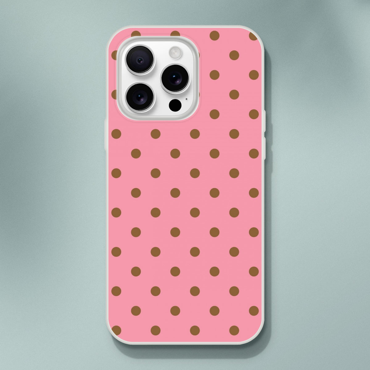 Retro pink and brown polka dot iPhone case with white bumper. Flexible TPU phone cover for iPhone 13-16 series offering slim, vintage-style protection.