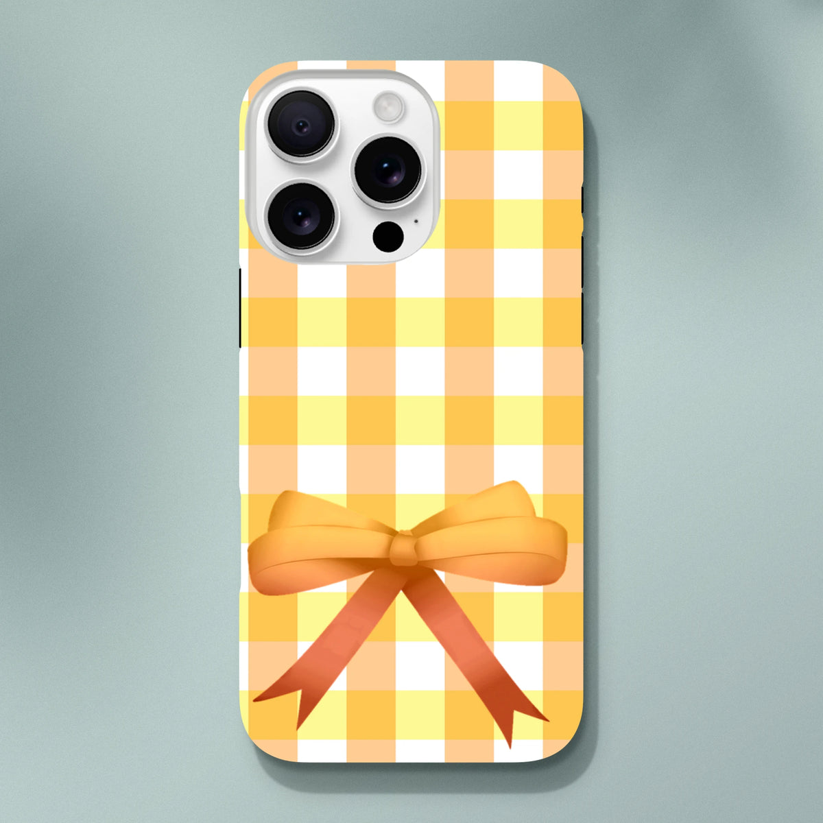 Yellow gingham iPhone case with a 3D orange bow for a cute coquette street style look compatible with iPhone 13-16.