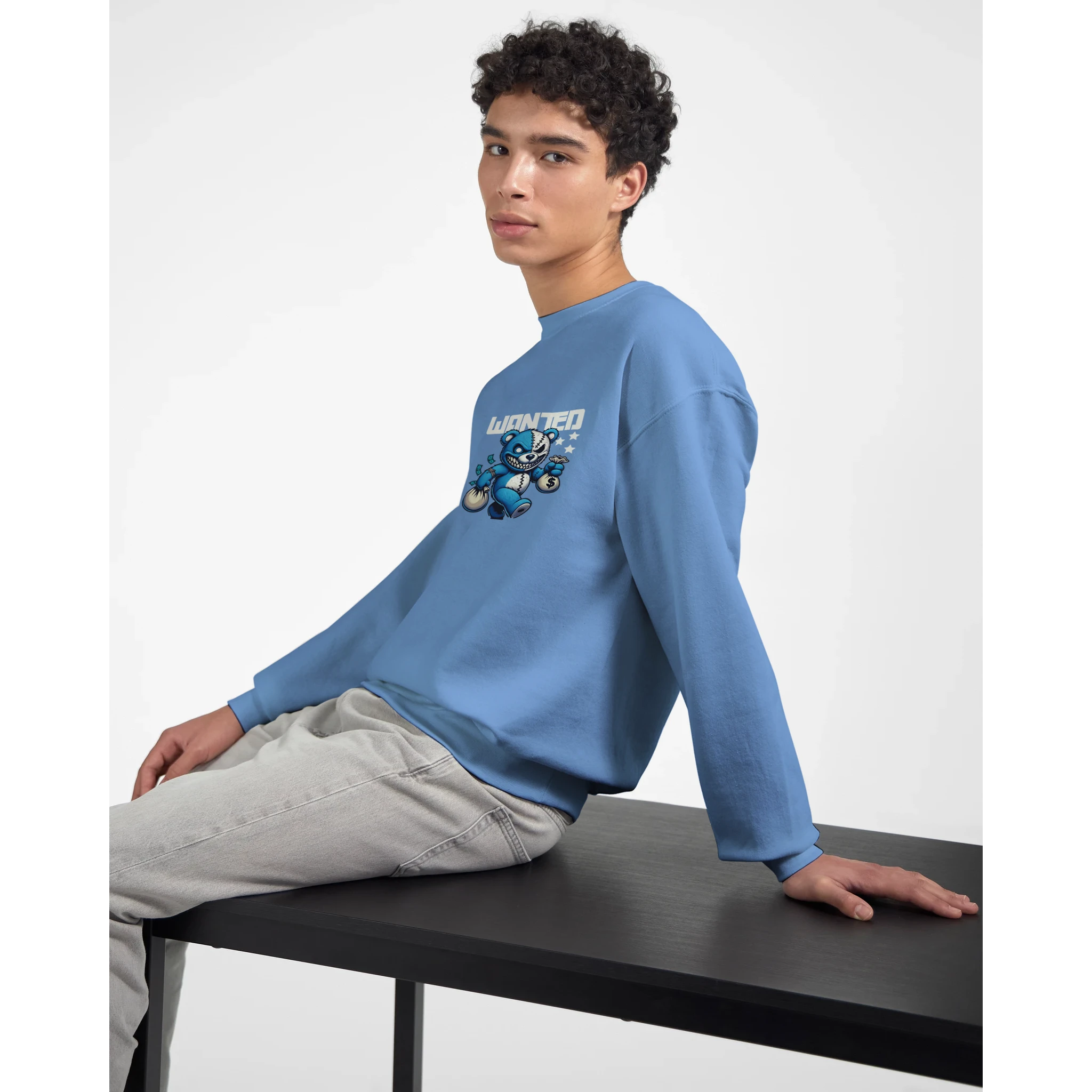 Model wearing blue cotton-poly blend men's graphic sweatshirt with teddy bear design and 'Wanted' text.