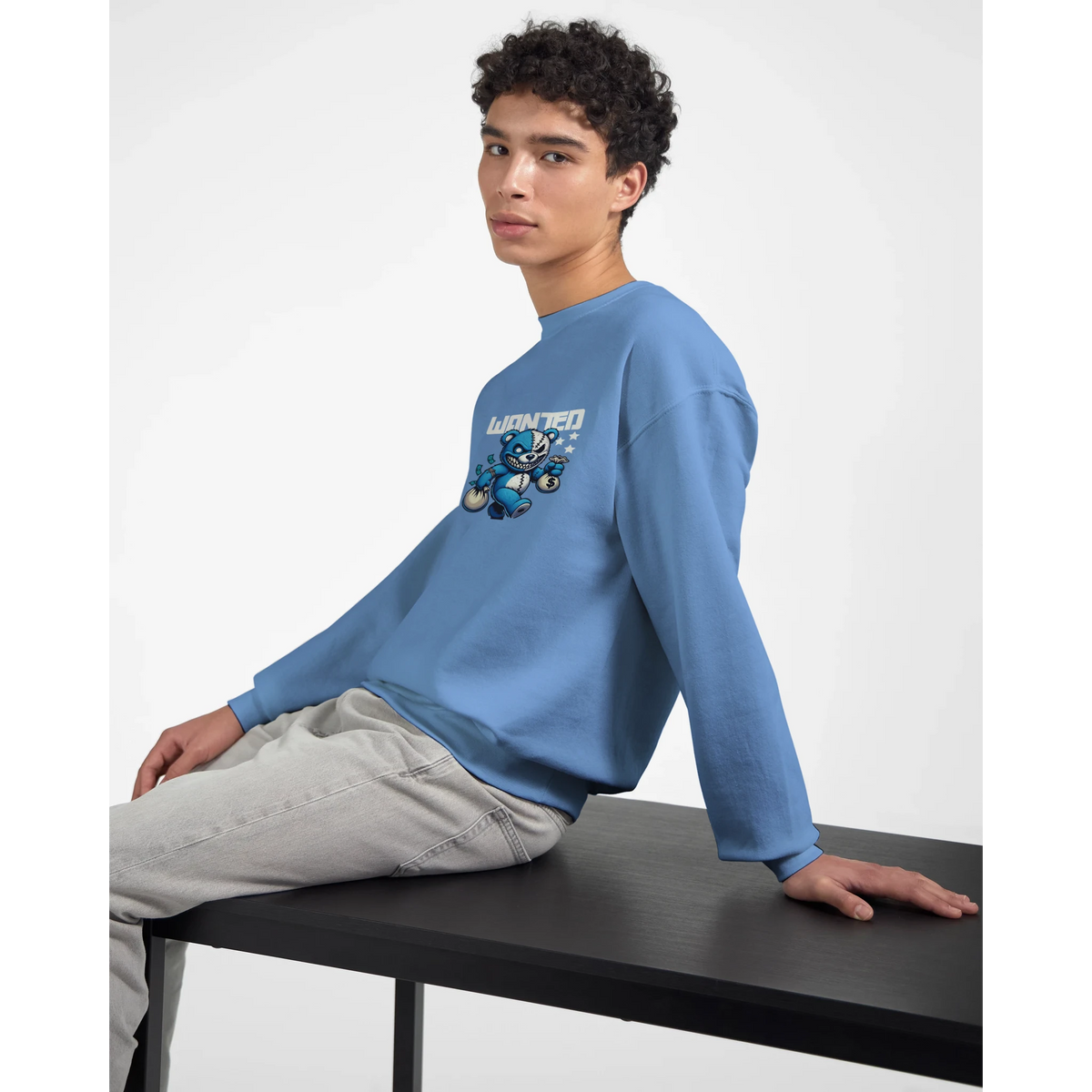 Model wearing blue cotton-poly blend men's graphic sweatshirt with teddy bear design and 'Wanted' text.