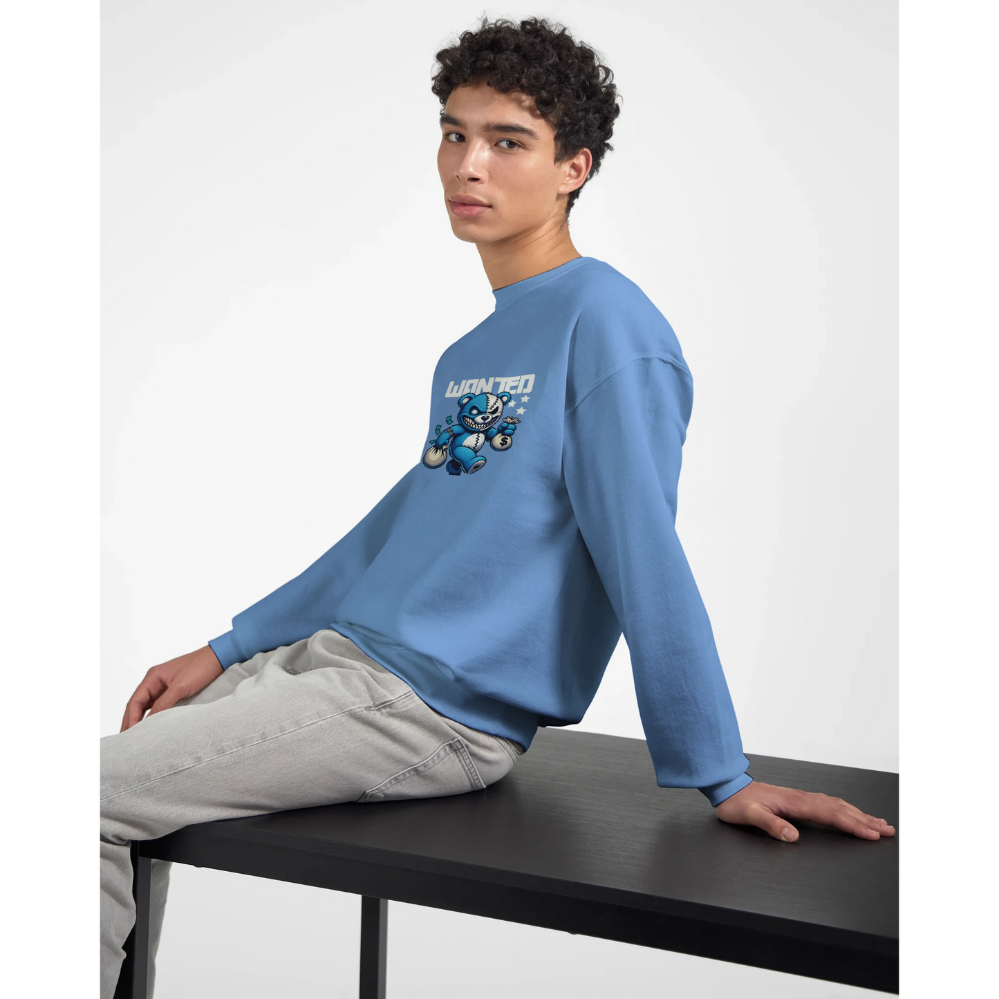 Person wearing a blue men's graphic sweatshirt with a graphic design sitting on a black table.