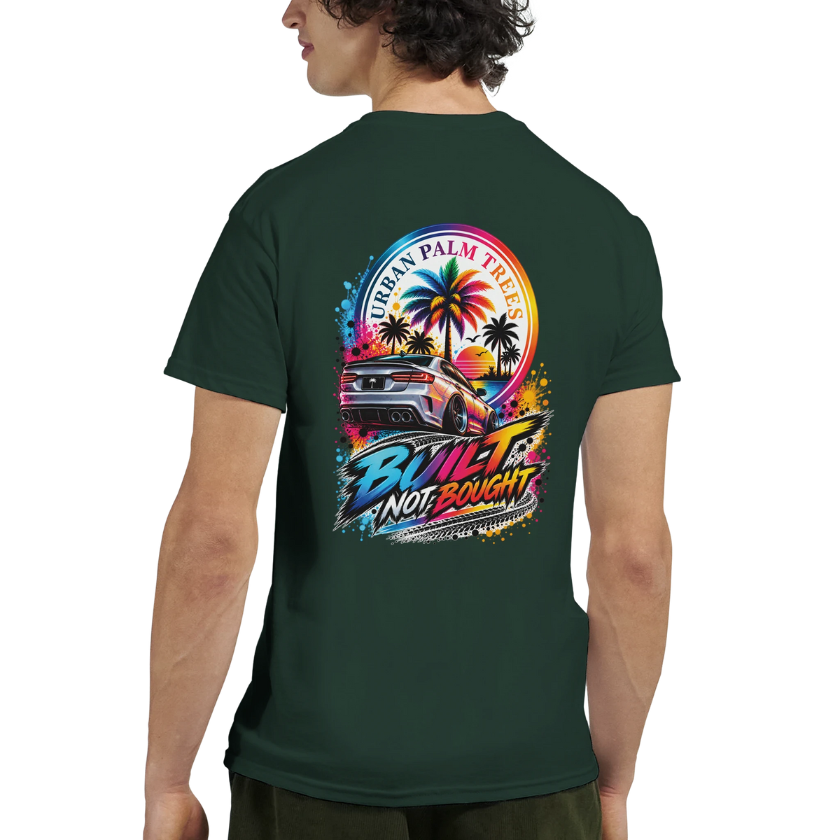 Dark green tee back featuring "Built Not Bought" graphic with modified car, palm trees, and sunset. Modified car culture streetwear.