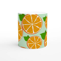 Cute orange citrus mug with orange slice pattern on mint-green background, perfect for coffee or tea.