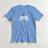 Light blue men's retro gamer graphic T-shirt with pixel-art controller and colorful arcade skyline.