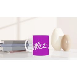 Cute Wild Heart Mug with slogan on purple ceramic, shown on a desk with books.