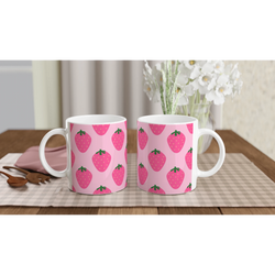 Pair of pink strawberry-pattern mugs on a checkered table, kawaii fruit coffee cups.