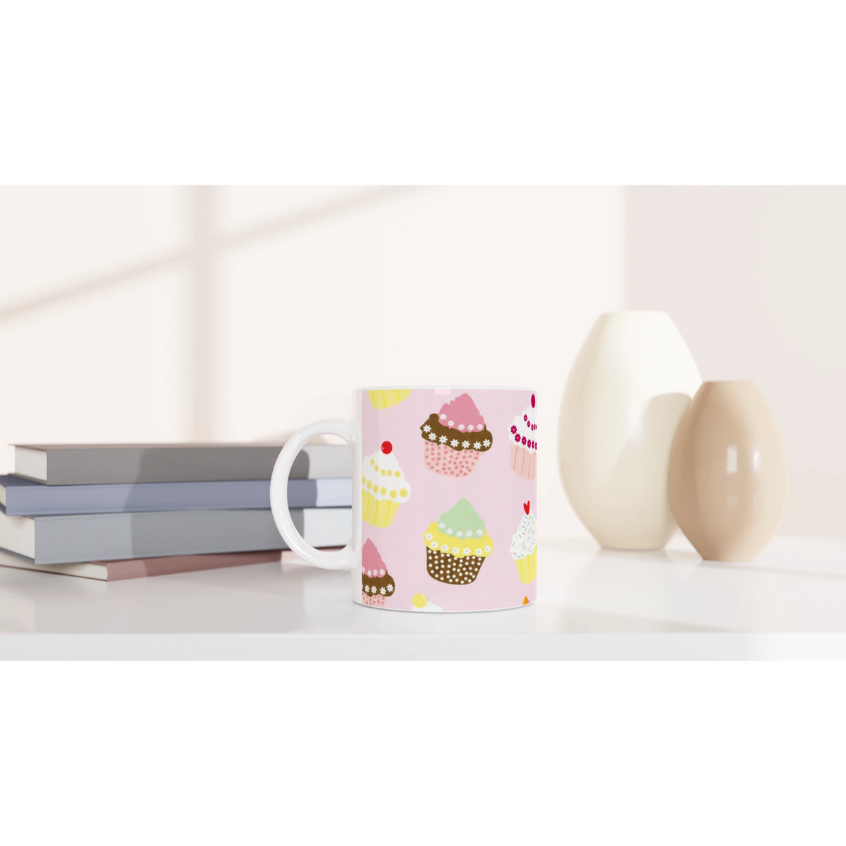 Cute Cupcake Mug - Pastel Kawaii ceramic coffee cup on a desk with notebooks and a lamp