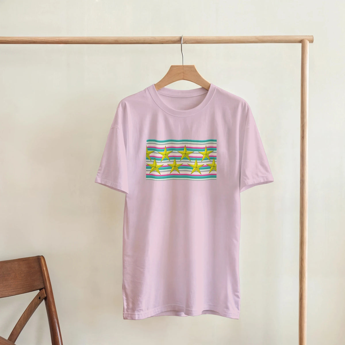 Pastel Stripe Gold Star Graphic T‑Shirt for Women on a wooden hanger.
