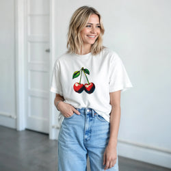 White retro cherry graphic tee for women paired with baggy blue jeans, featuring vintage fruit design and clean lines.