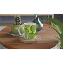 Lime Slice Pattern Ceramic Mug - Citrus Coffee Cup with lime designs on a wooden table beside a cactus planter.