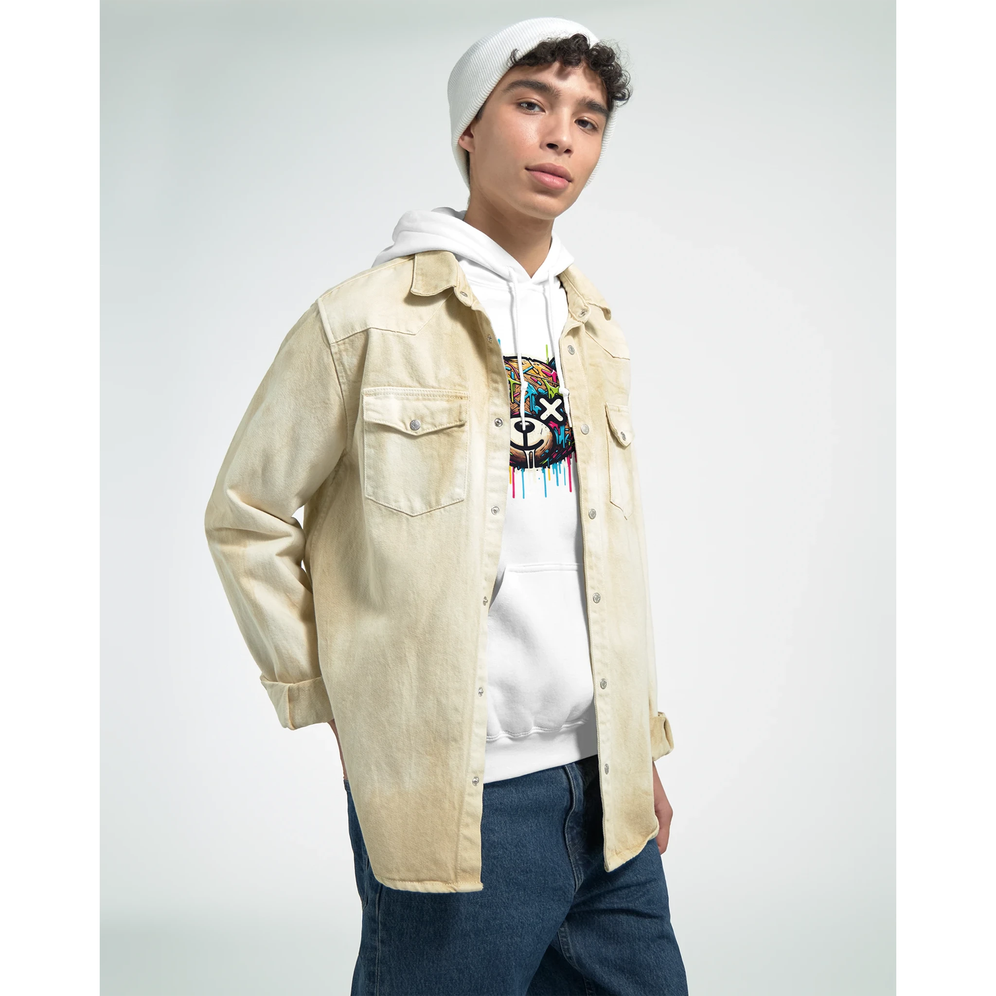 Male model in white teddy bear hoodie with colorful graphic, layered under beige denim jacket, casual streetwear.