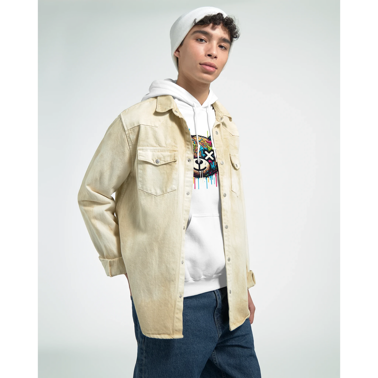 Person wearing a beige jacket, white men's teddy bear hoodie, and colorful shirt on a plain background