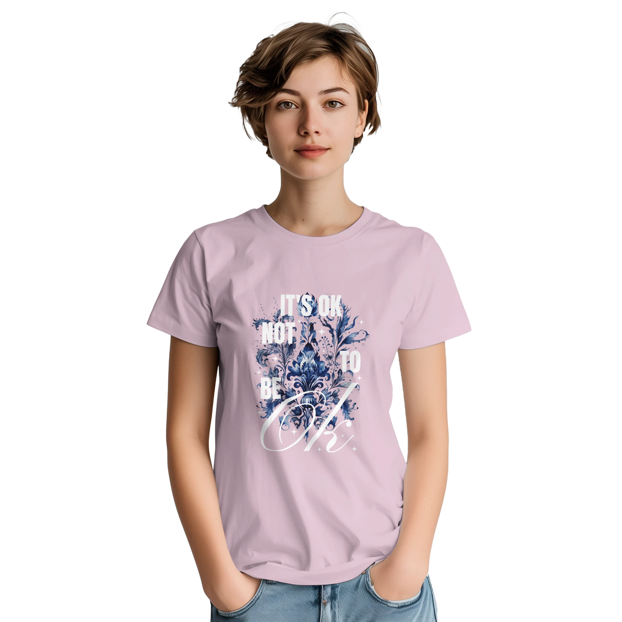 Woman wearing pale pink cotton-blend tee with blue floral graphic and It's OK Not To Be OK slogan.