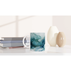 Blue Marble Mug with ocean-abstract glaze on ceramic coffee cup beside stacked books.