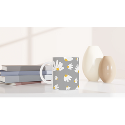 Ditsy Daisy Mug with white daisies on gray, a cute floral coffee cup for daily coffee or tea on a desk.