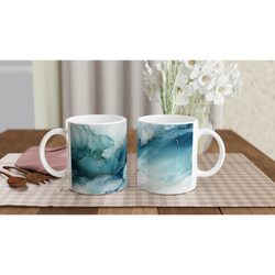 Blue marble ceramic mugs with an ocean-abstract glaze on a checkered table, white flowers in the background.