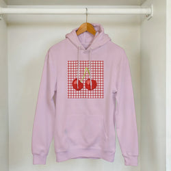 Pink retro cherry gingham hoodie for women with cherry graphic, hanging on a wooden hanger.