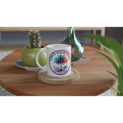 Urban Palm Trees mug with vibrant palm tree artwork on a wooden table beside a cactus.
