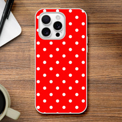 Retro red and white polka dot iPhone case providing slim, shock-absorbing protection for models 13 through 16 on a wooden desk.
