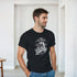 Man models Gothic Glory graphic T-shirt in black with a statue motif and ornate circular design.