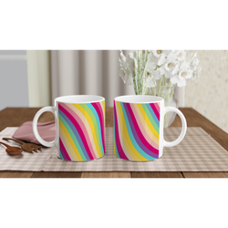 Retro Rainbow Stripe Ceramic Mugs - two colorful striped coffee cups on a wooden table with white flowers.