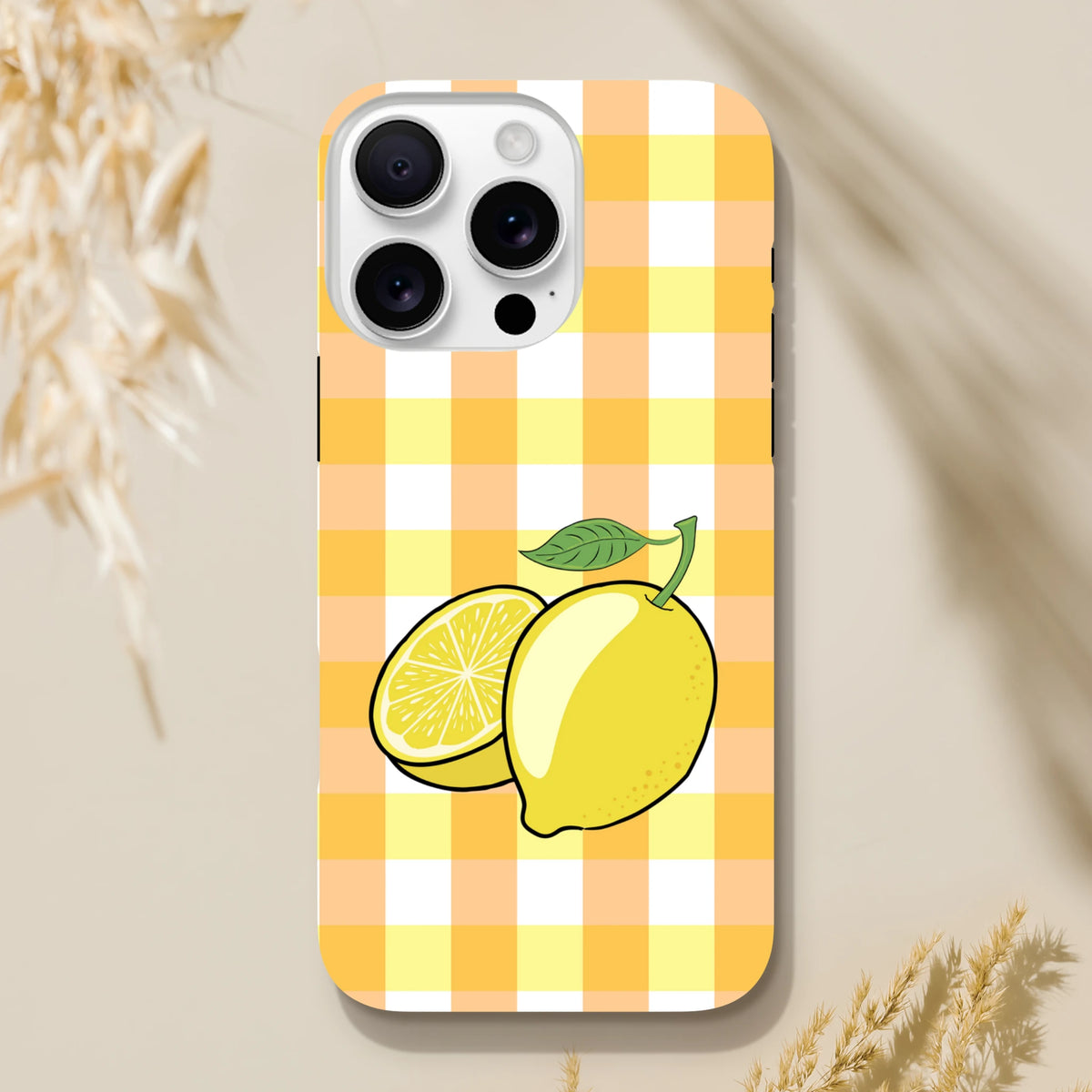 Yellow gingham iPhone case featuring a whole and sliced lemon illustration with green leaf on checkered pattern.