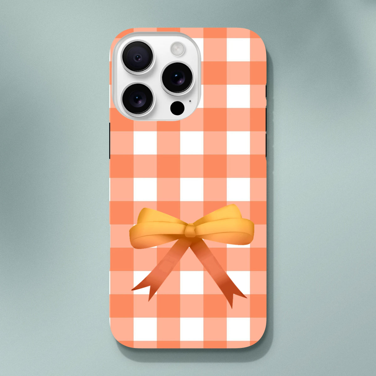 Orange gingham iPhone case featuring a 3D bow and tough, impact-resistant protection in a cute coquette style.