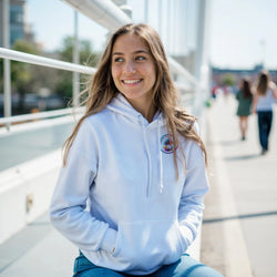 Woman smiling in white retro graphic hoodie with front pouch pocket and double-lined hood for casual streetwear.