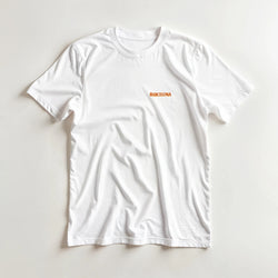White Barcelona travel tee with small orange BARCELONA text on chest.