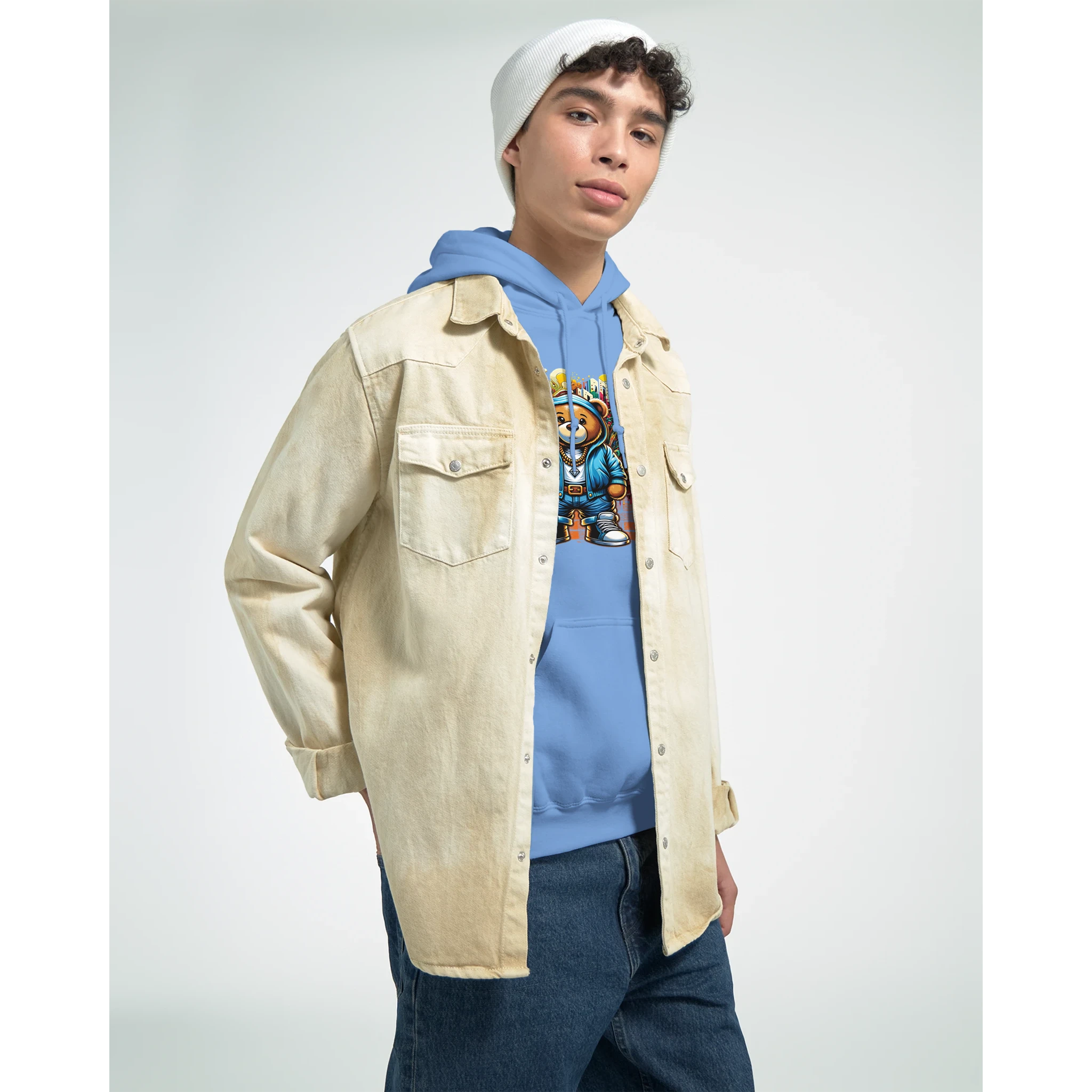 Male model wearing blue Urban Teddy Bear hoodie with bear graphic, layered over a beige overshirt and white beanie.