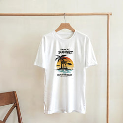 White t-shirt featuring a vintage tropical sunset graphic with palm trees and "Tropical Sunset Beach Resort" text.