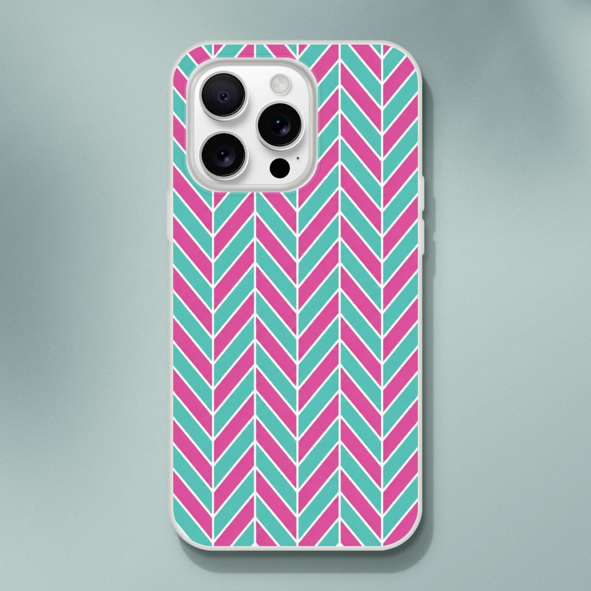 Pink and turquoise herringbone iPhone case with geometric chevron pattern, matte TPU cover for wireless charging and impact protection.