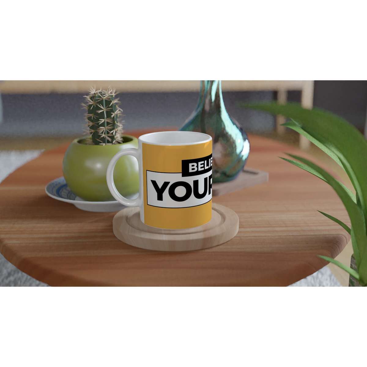 Yellow Believe In Yourself mug with bold slogan on a wooden table beside a cactus and plants.