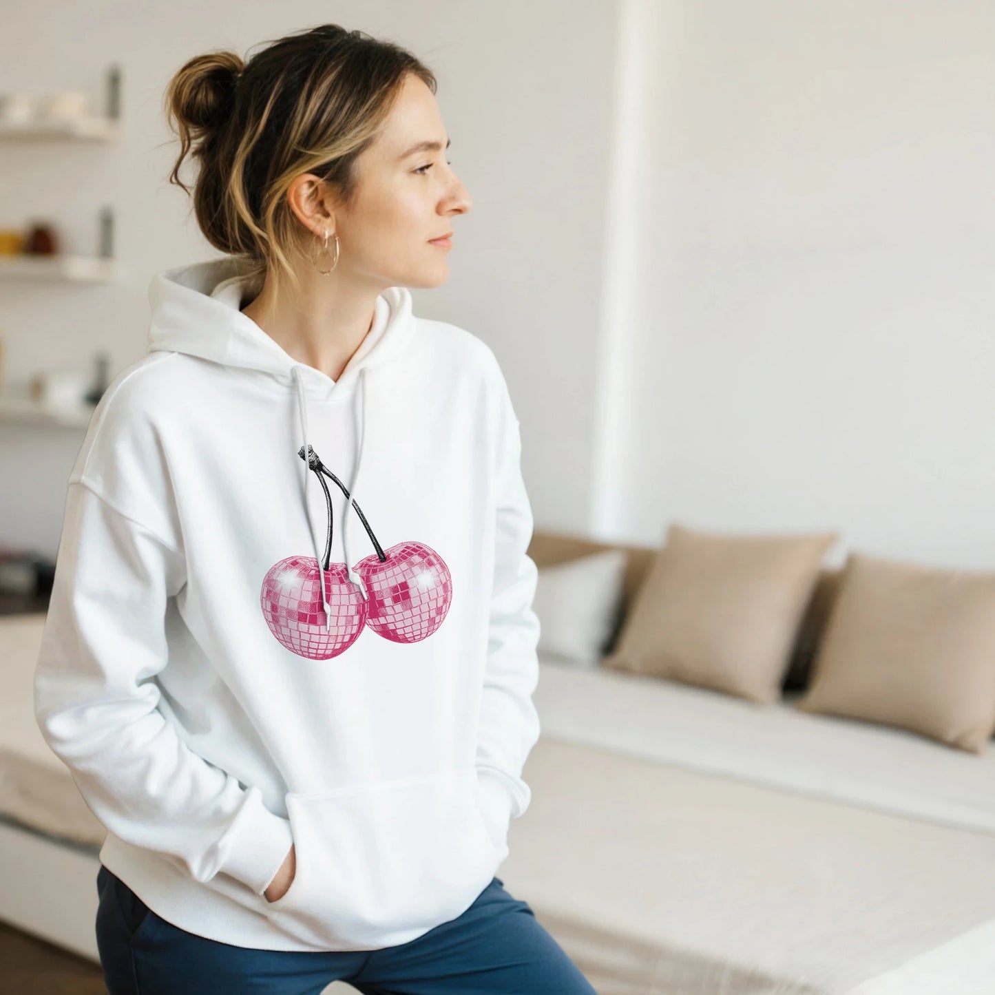 Glitter Ball Cherries jumper hoodie: white cotton blend with pink glitter cherry graphic worn by a woman.