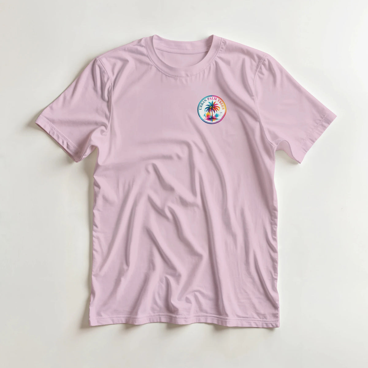 Pink women's graphic tee featuring a colorful retro circular Urban Palm Trees logo on the chest.