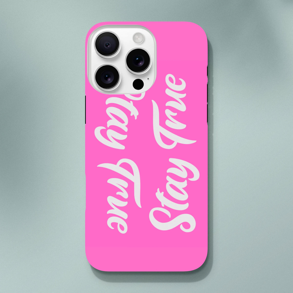 Hot pink iPhone case featuring white "Stay True" script text. Tough protective cover with positive quote for iPhone 13-16 models.